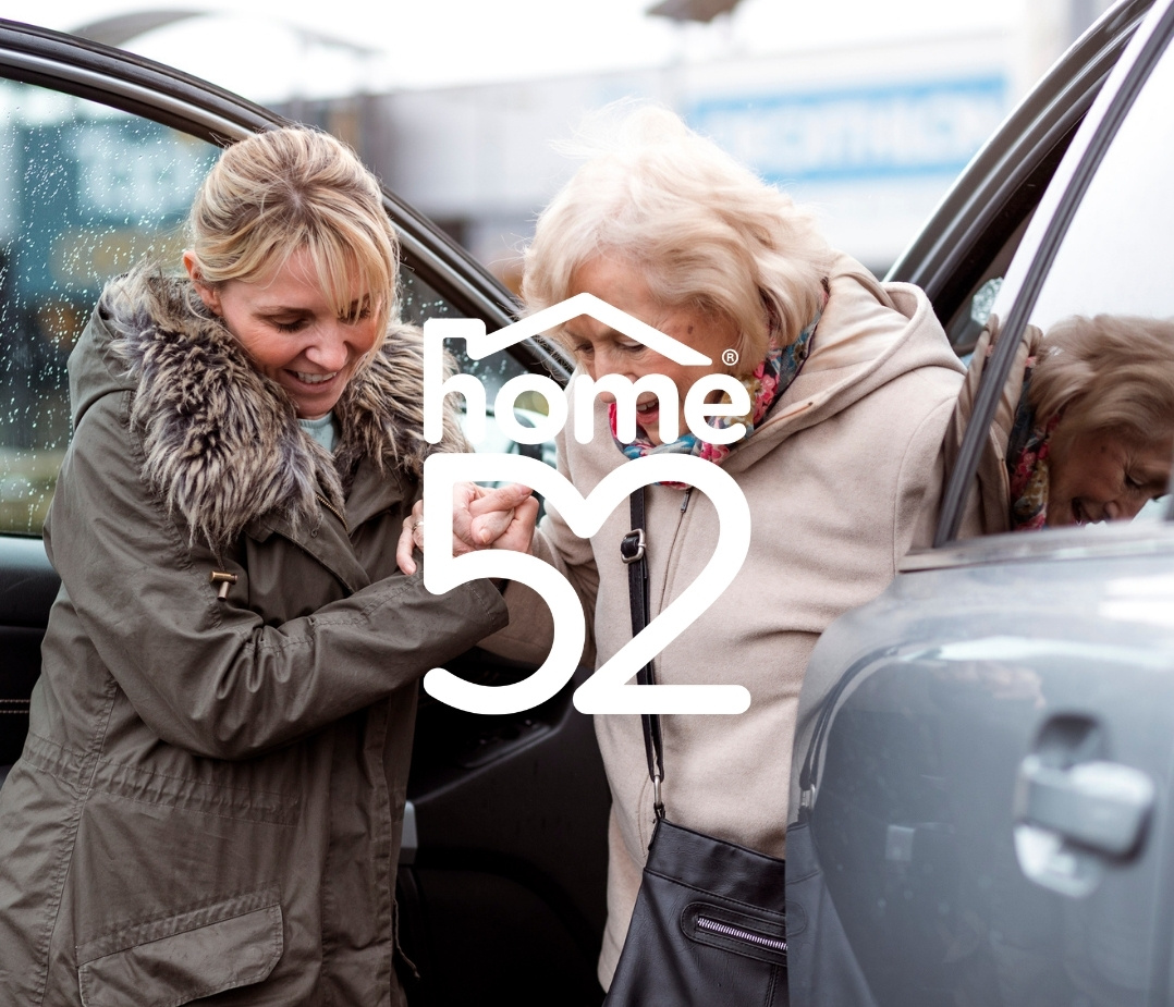 young woman helping an older woman out of a car