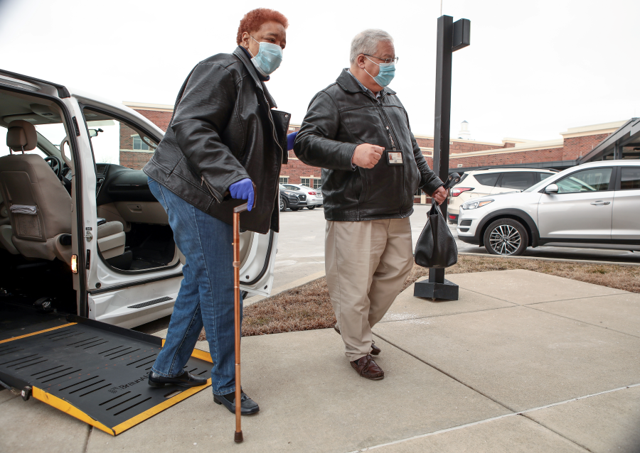 senior woman being assisted while exiting car