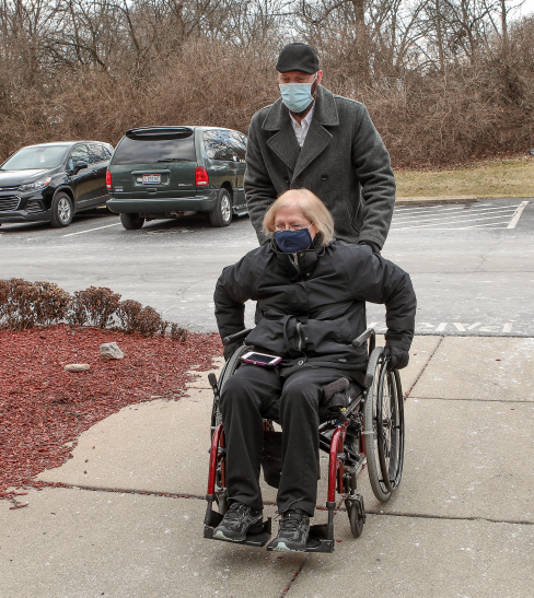 Woman in wheelchair being pushed by a man
